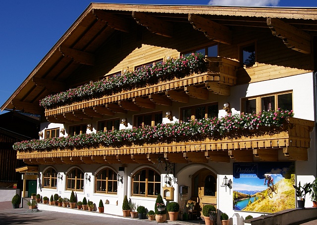 Unsere Unterkunft: Brenner's Dorfstube in Fieberbrunn von außen. Zu sehen ist ein zwei-stöckiges Appartementhaus im typischen lokalen Baustil.